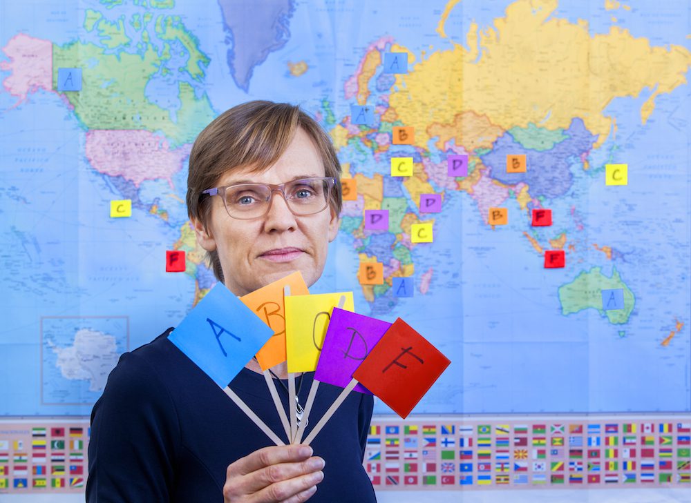 Judith Kelley near a map with flags that rank countries
