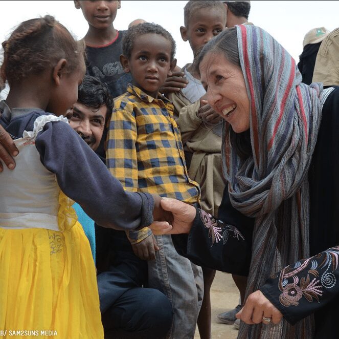Abby Maxman in Yemen looking at a child