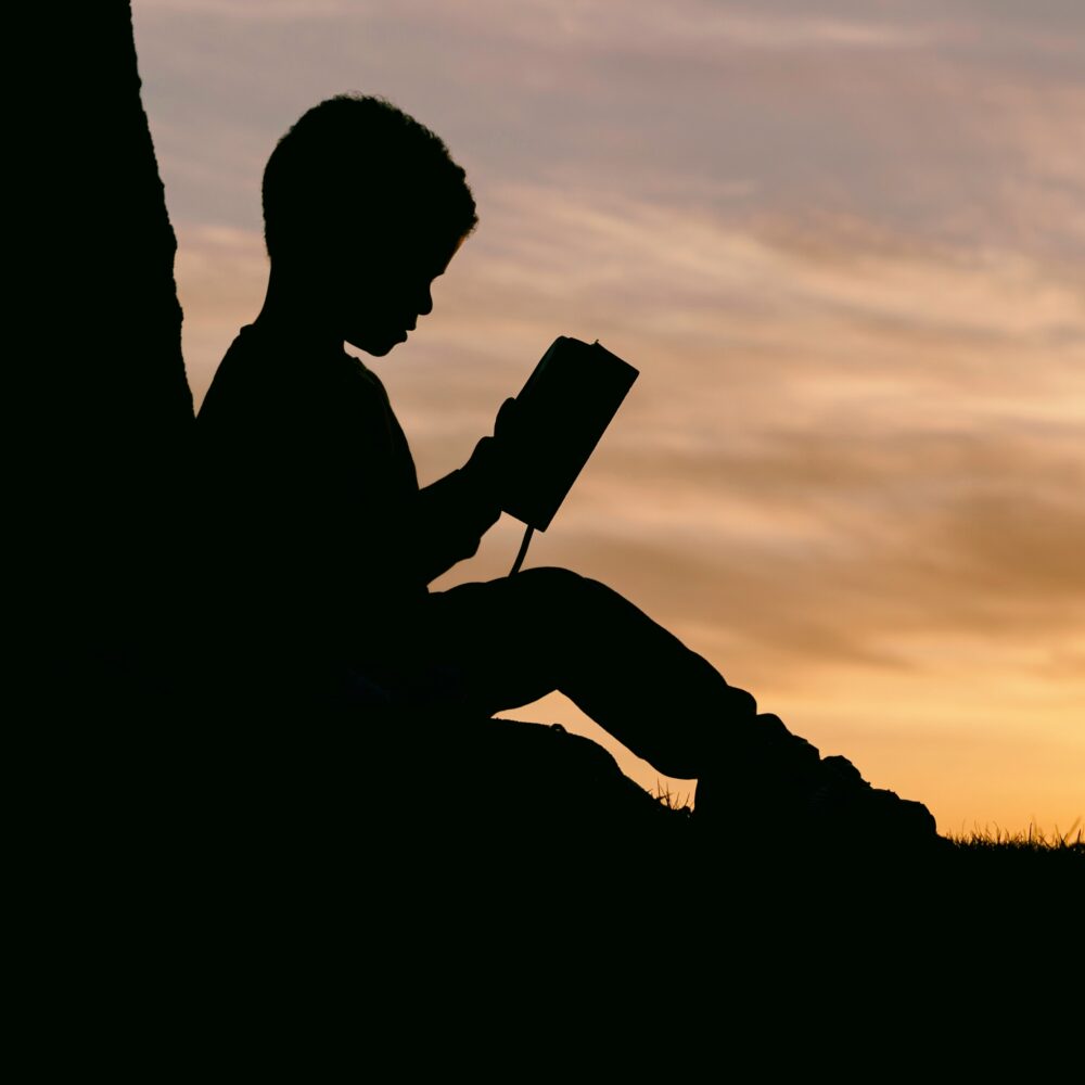 silhouette of child reading